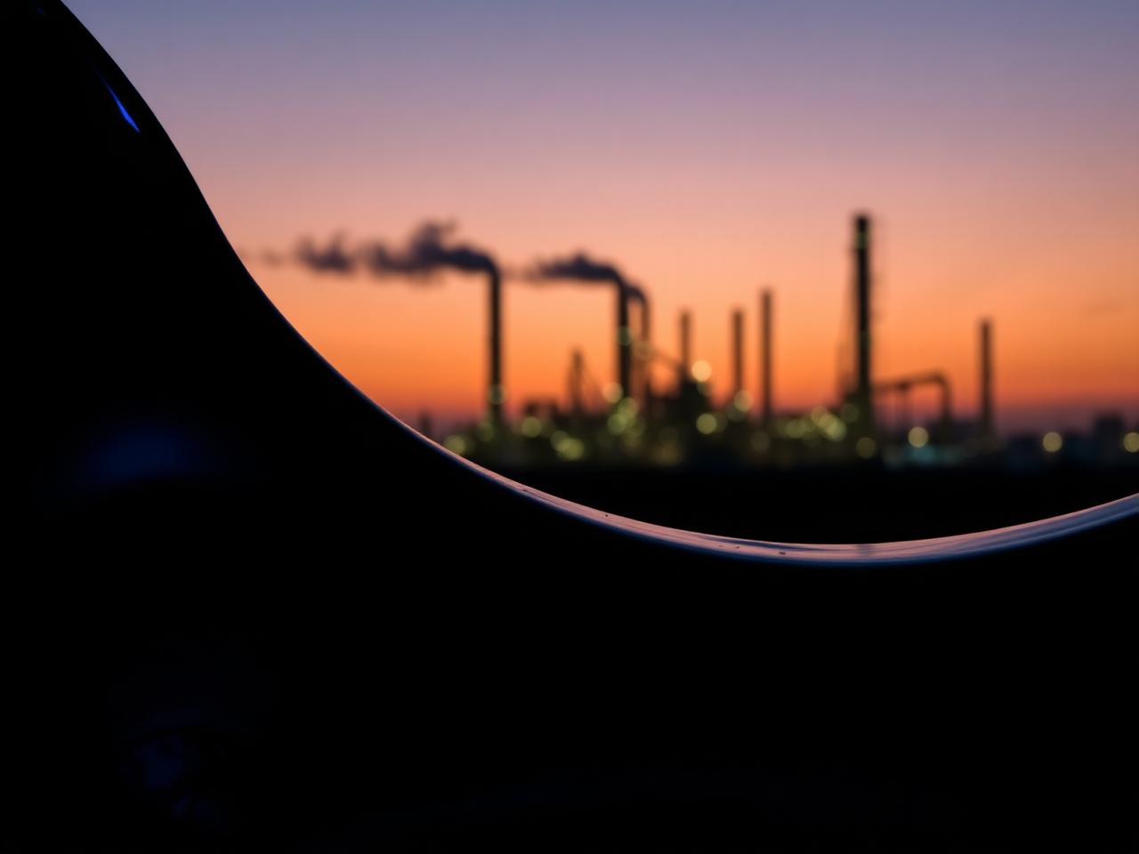 Silhouette d'une raffinerie au crépuscule — marchés de l'énergie